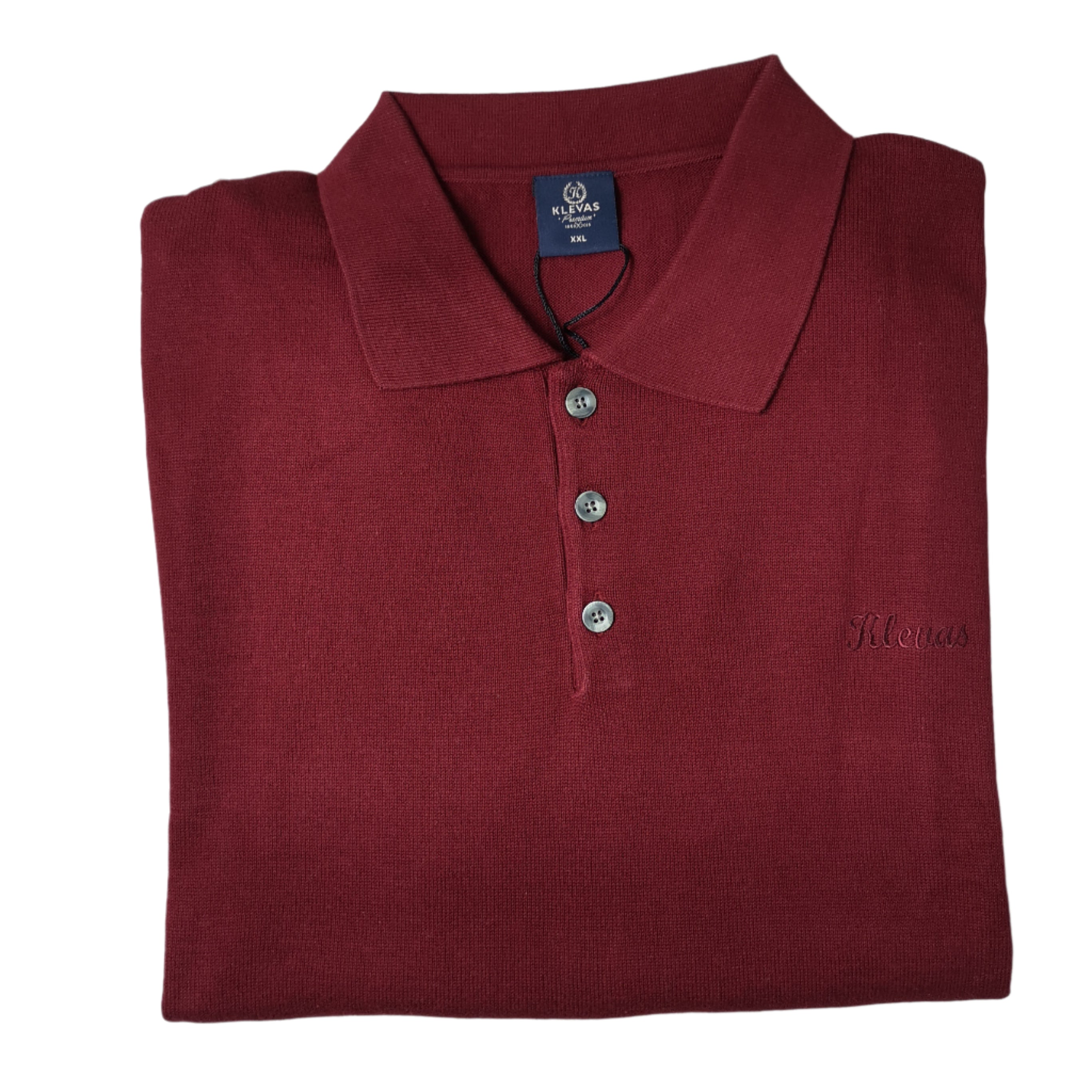 Folded maroon polo shirt with a brand label on a white background